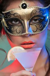 Woman in mask holding glass of drink