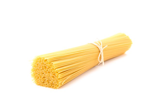 Pasta isolated on bright background, closeup. Dry uncooked whole pasta