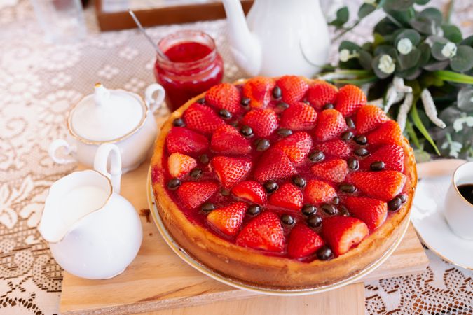 from above a strawberries cake on table with coffee and milk