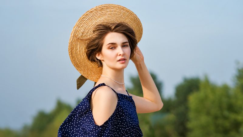 Young woman in straw hat outdoors