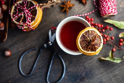 Top view close up of orange slice balancing on mug of warm tea