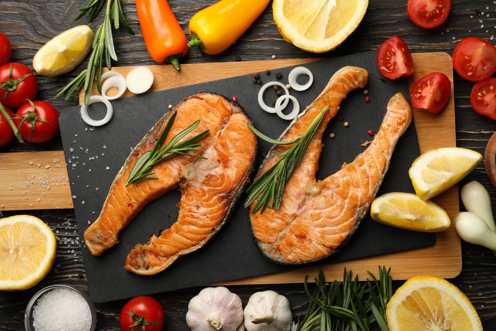 Composition with tasty grilled salmon on wooden background, top view