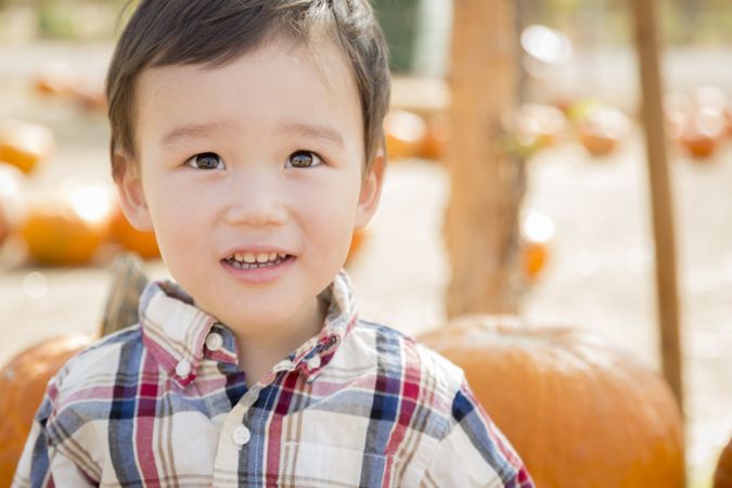 Biracial Boy Having Fun at the Pumpkin Patch
