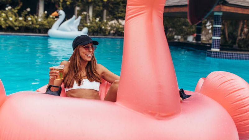Woman relaxing at pool party with beer