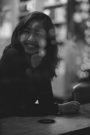 Grayscale photo of smiling woman in dark top