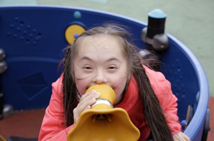 Adorable little girl talking though playground megaphone