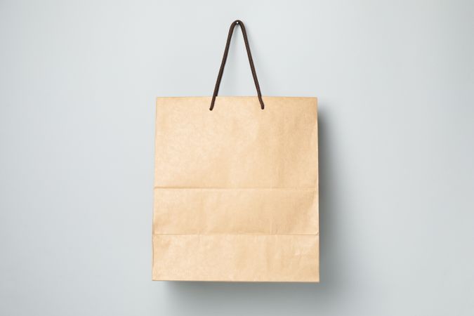 Empty paper bag on gray background, space for text.