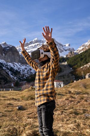 Child wearing VR headset in yellow valley in mountainous area
