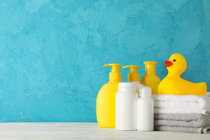 Baby hygiene accessories on wooden table against blue background