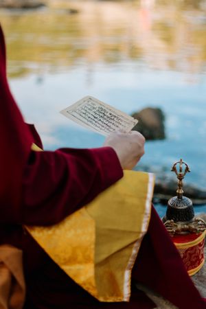 Cropped image of Buddhist monk holding a piece of paper