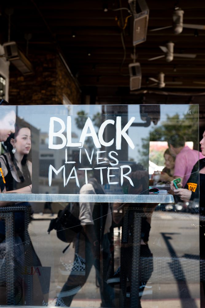 Los Angeles, CA, USA — June 14th, 2020: people sitting at restaurant behind window during protest