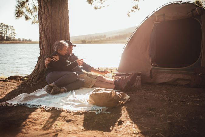 Portrait of loving couple camping near a lake on a beautiful summer day