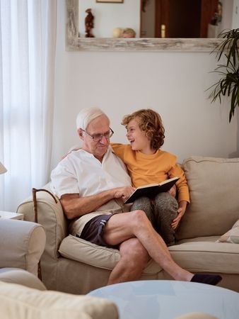 Positive boy reading book with grandfather