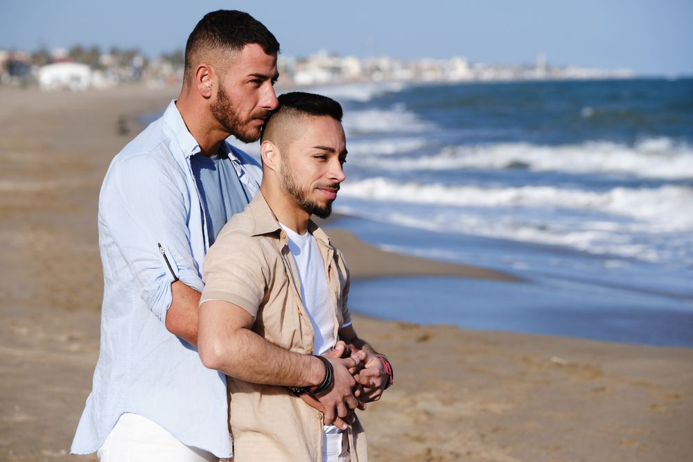 Male couple hugging on seaside