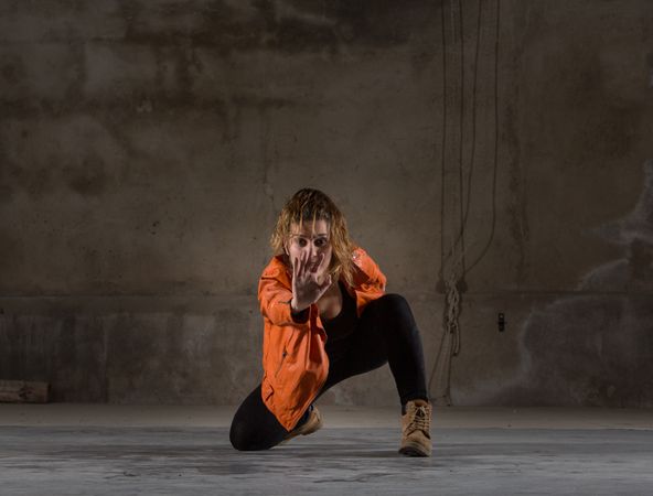 Young woman jumping in grey room