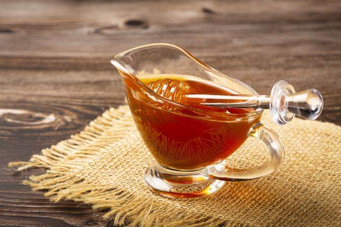Honey in glass bowl on the table.