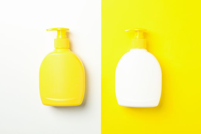 Blank bottles for soap on two tone background, space for text