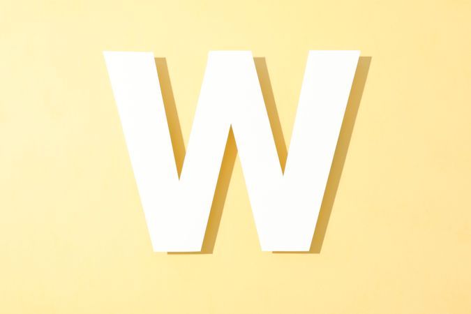 Paper letter W on color background, space for text