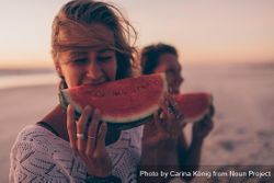 Young woman eating a watermelon slice at the beach Bbxdnb