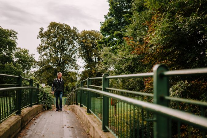 Man walking on bridge in park