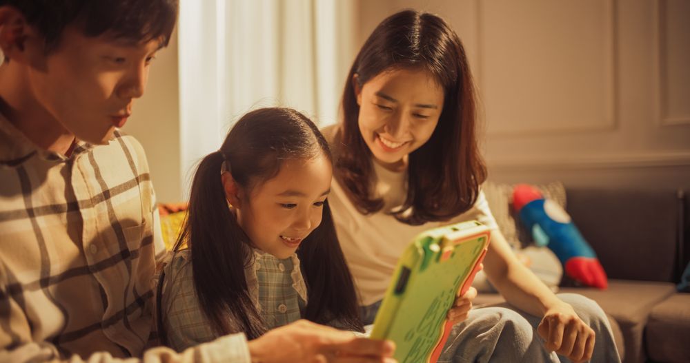 Close Up of a Korean Family Spending Time Together, Using Digital Tablet Computer at Home.