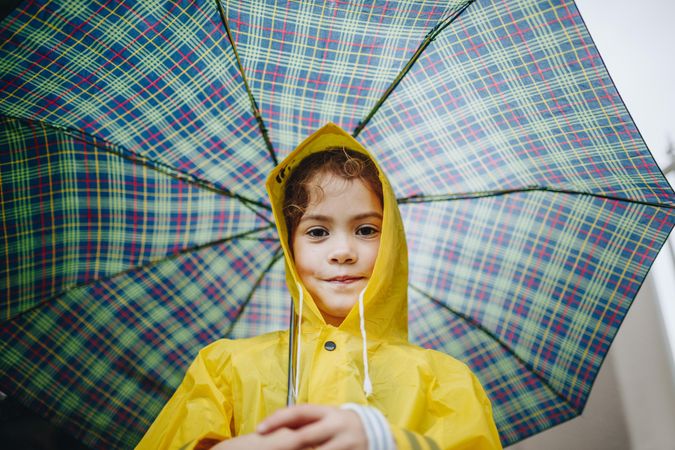 Portrait of cute little girl with umbrella on rainy day