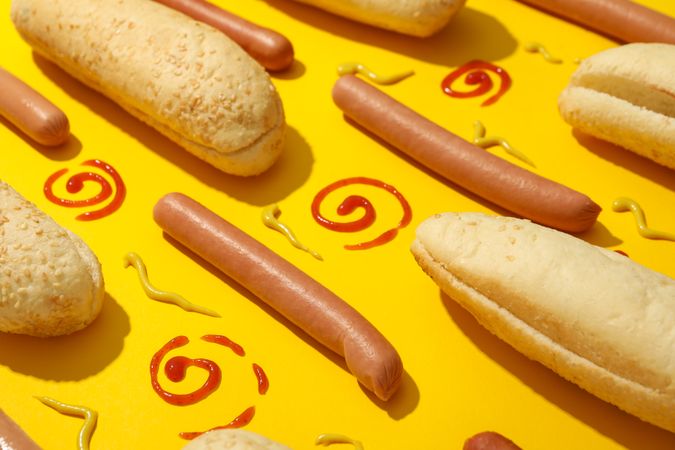 Flat lay with ingredients for hot dog on yellow background