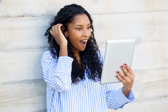 Young Woman with a Look of Surprise and Joy as She Enjoys Her Tablet Experience Bravo