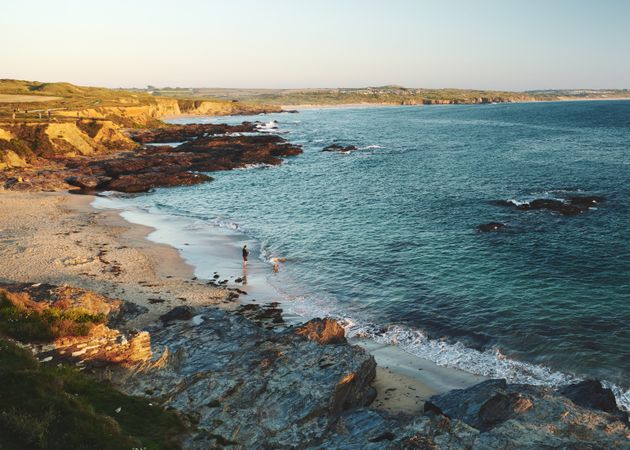 Single person looking out at the sea from a rocky beach