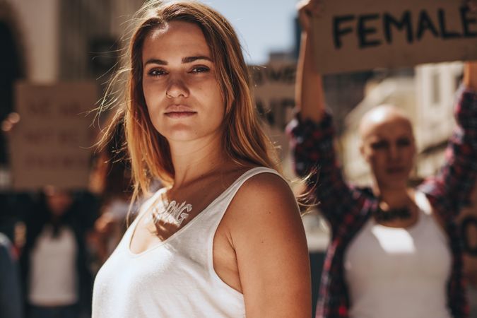Woman activist with word strong written on her body standing outdoors