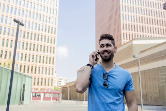 Smiling man talking on his phone outdoors