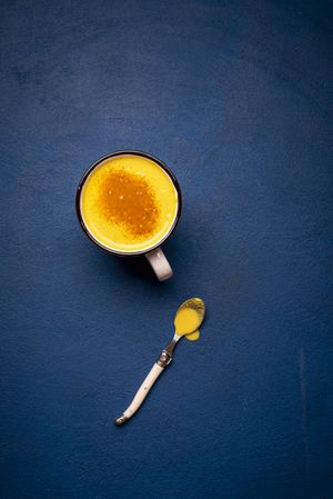 Turmeric latte on a deep blue table