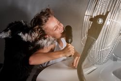Preteen kid singing into comb and playing with dog in front of w