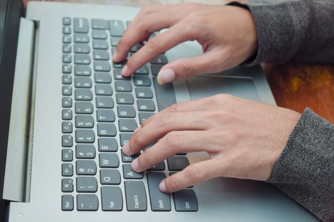 Man typing on laptop on table in livingroom