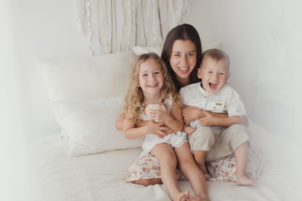 Content young mother with little kids at bedroom