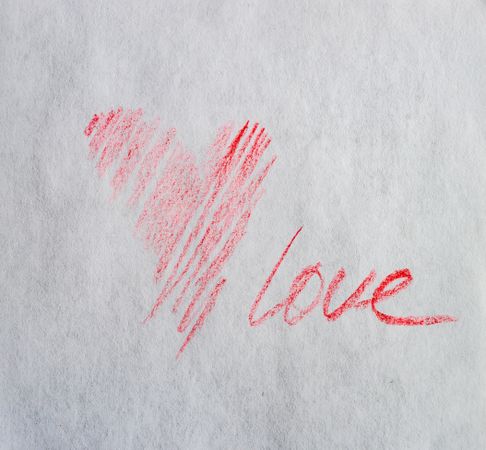 Valentine Day holiday card concept with red heart and love scribbled on paper