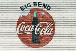 An old company sign appears on the wall of a Coca-Cola bottling plant outside Alpine, Texas A0yER0