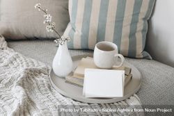 Stylish interior still life with cup of coffee, tea on pile of books on tray with mock up card 49jdWb