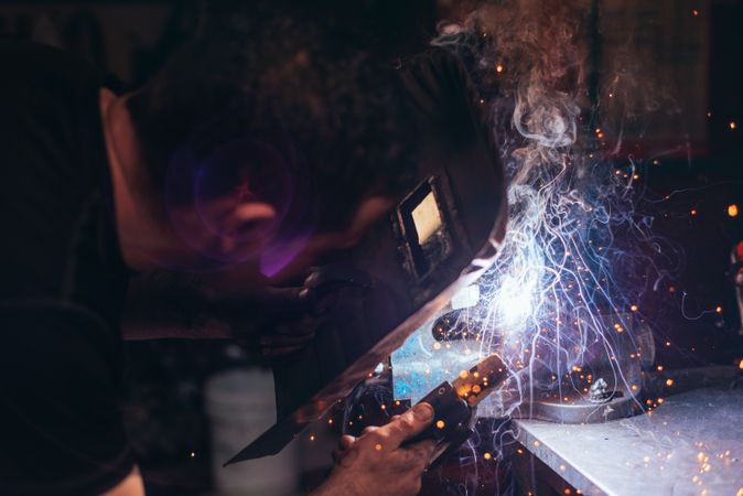 Professional welder in mask welding metal