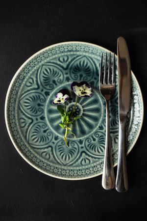 Spring table setting with delicate purple flowers on green patterned plate