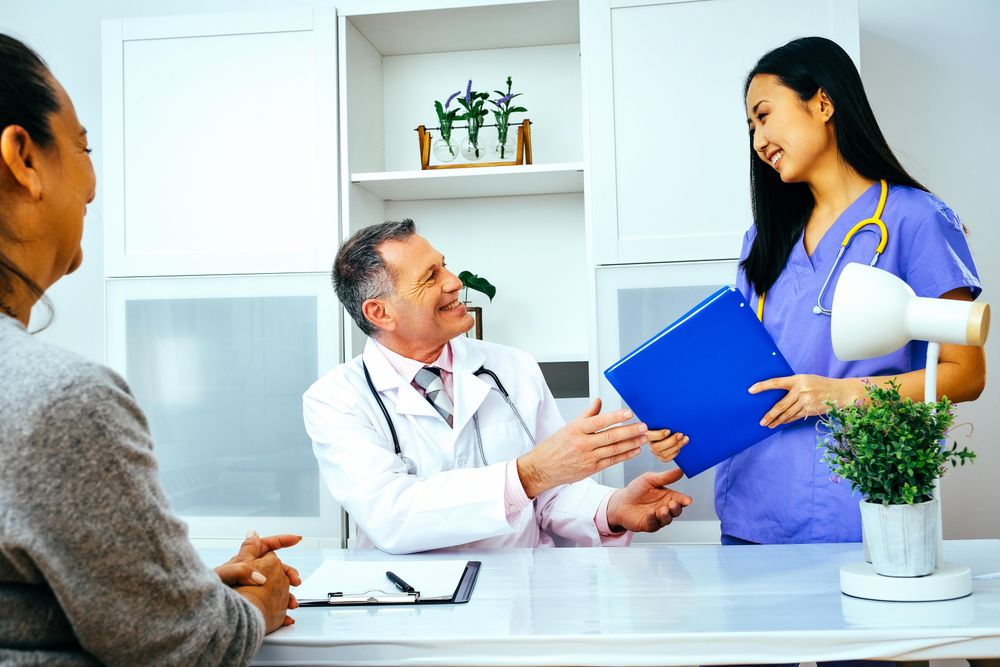Nurse handing doctor patient’s file in office