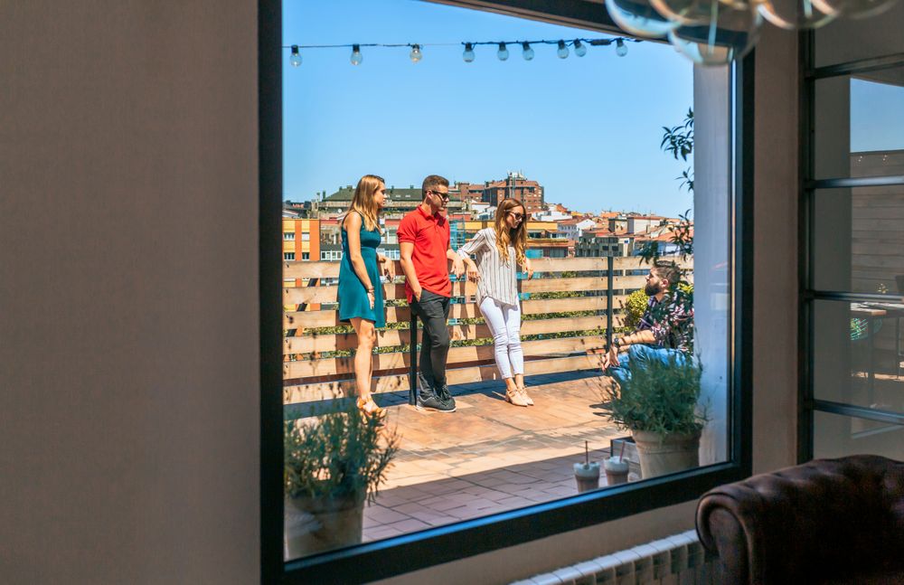 View of friends group talking in rooftop through lounge window