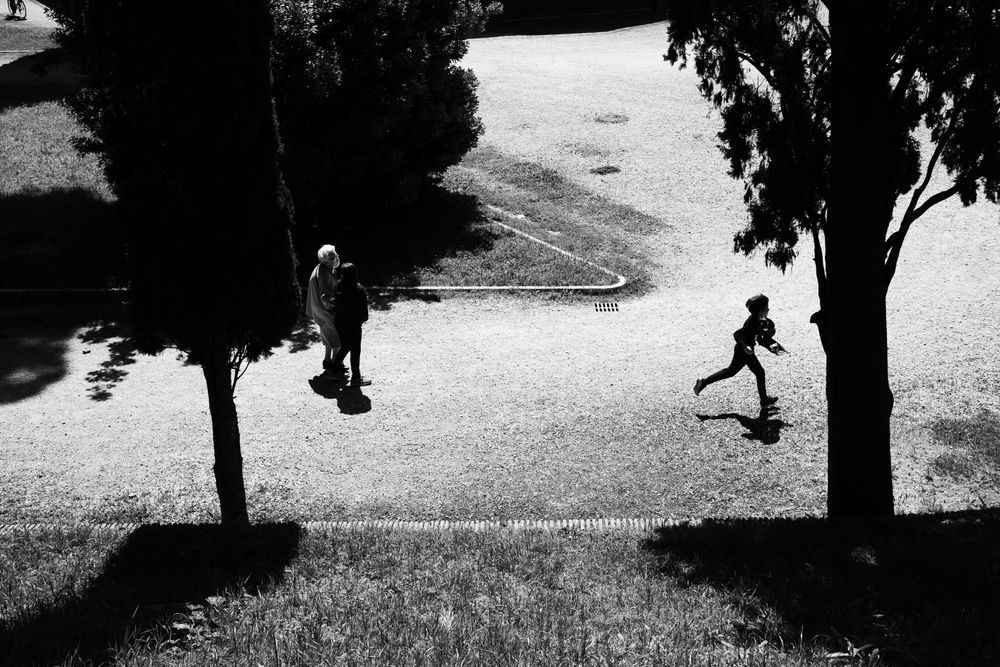 Two young people playing with their grandmother in park