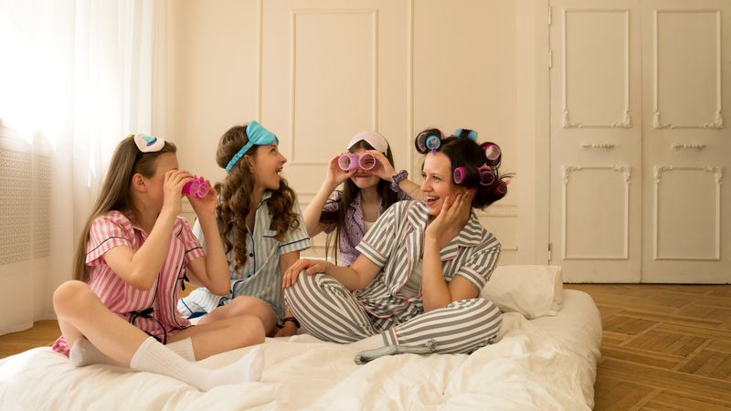 Girls enjoying playful moment with hair rollers and pajamas