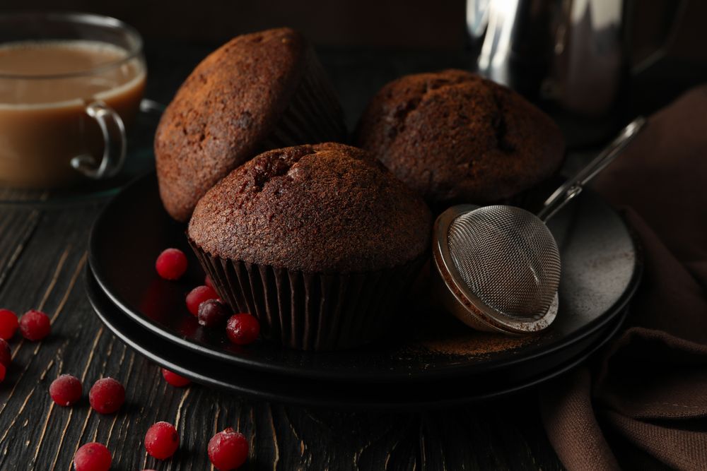 Composition with tasty muffins and cocoa drink on wooden background