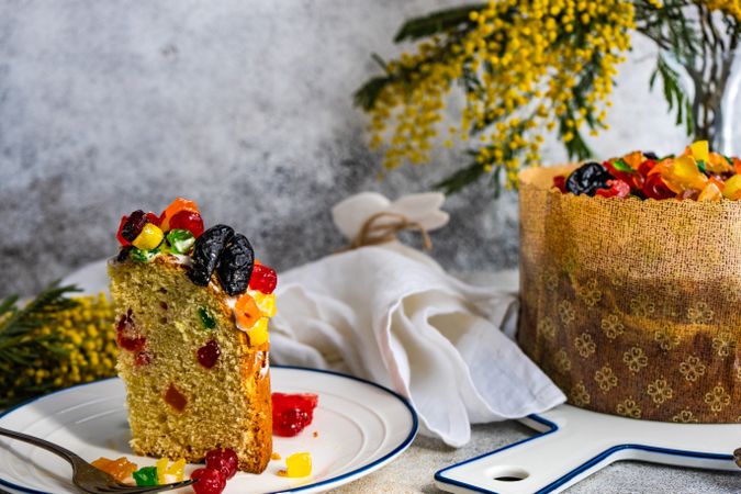 Side view of Easter food concept with fruit cake and yellow spring flowers