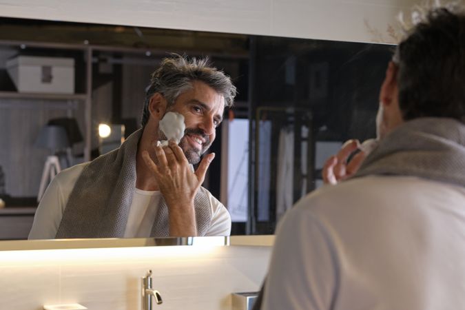 Mature male applying shaving foam in bathroom