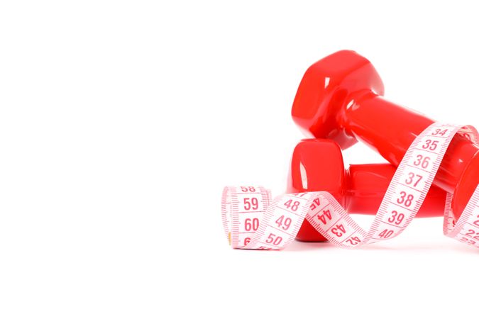 Dumbbells and measuring tape isolated on plain background