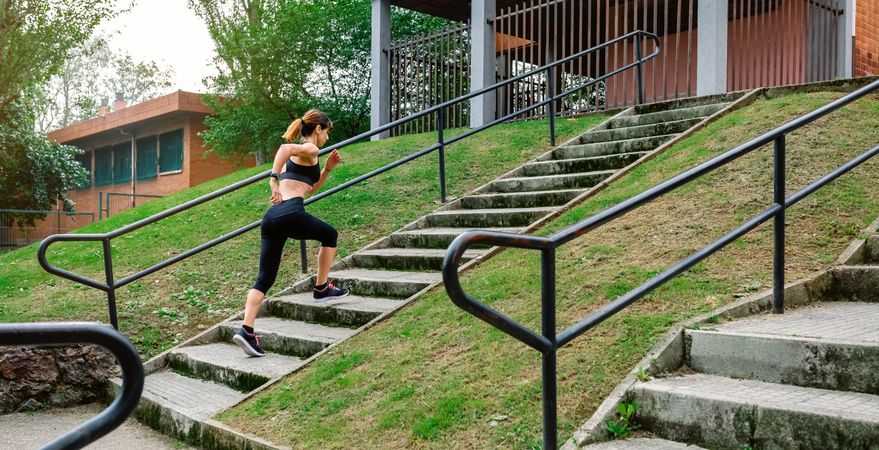 Female athlete climbing stairs outdoors