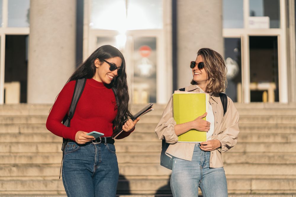 Two students leaving class down the stairs. Blonde and brunette